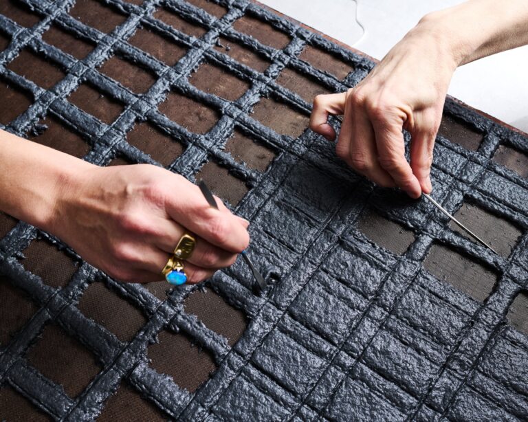 Artist Sam Moyer works with Director of Artistic Projects and Master Collaborator Tatiana Ginsberg to "excavate" pulp from a cotton sheet to creating a grid-like image. Murray Hall