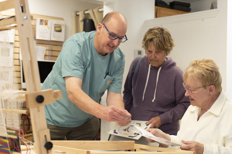 Cael assisting community members with loom assembly. Photo by Max Woltman