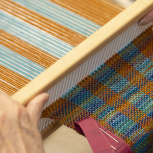 Jan weaving on a rigid heddle loom. Photo by Max Woltman