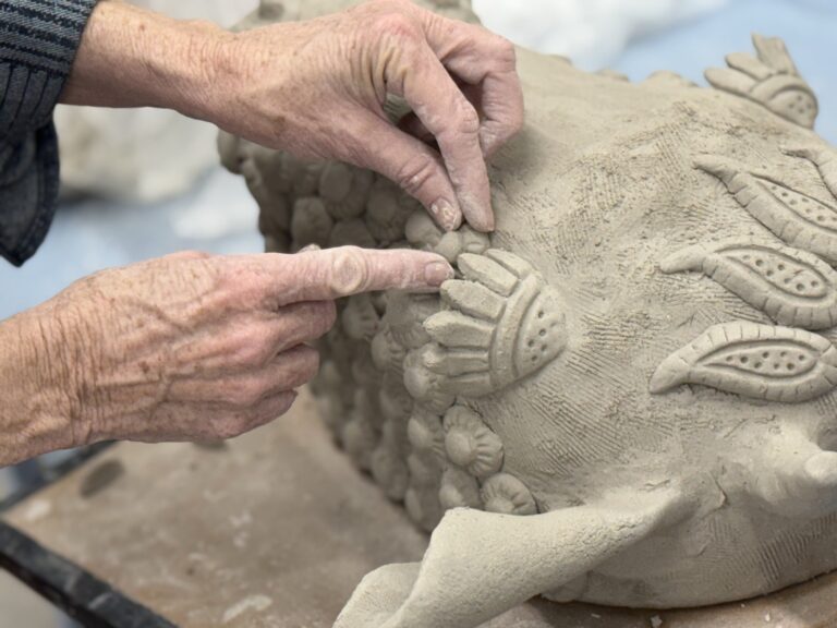 An artist adds sprigs to her clay mask in George Rodriguez's Handbuilt Ritual Mask Retreat Workshop. Hambidge Staff