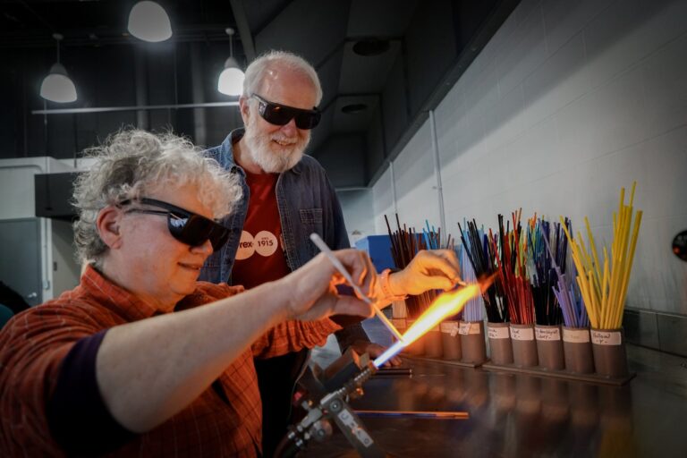 A Studio guest makes their own glass bead during a flameworking experience. Courtesy of Corning Museum of Glass. A Studio guest makes their own glass bead during a flameworking experience. Courtesy of Corning Museum of Glass.