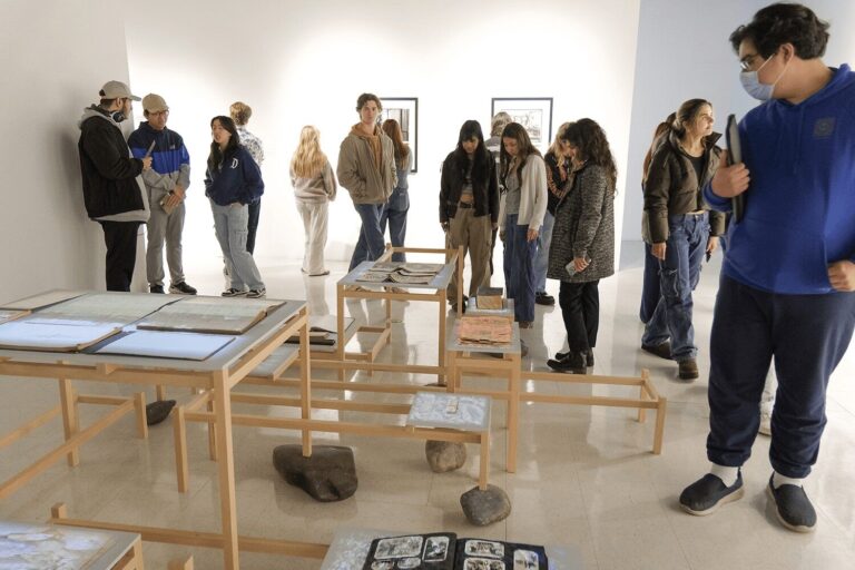 Gallery event with visitors and artwork in the background. Image courtesy of Ken Jacques