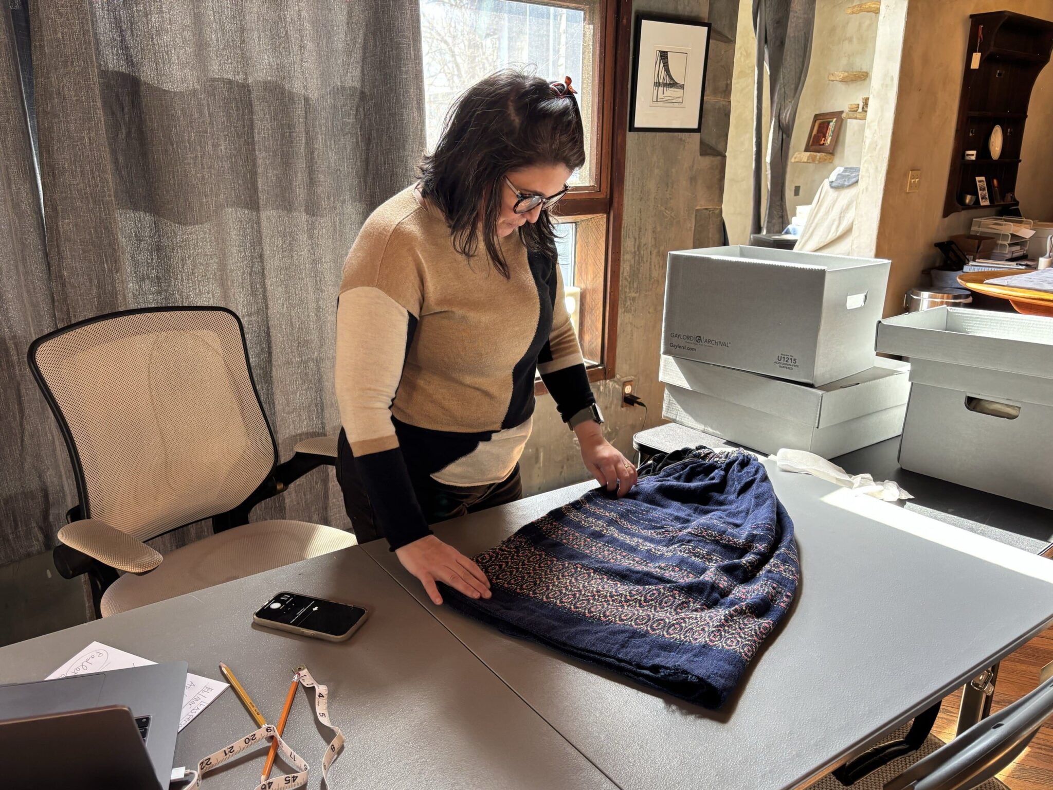 WEM Artist-in-Residence Kelly Cobb examining a handwoven and embroidered cotton skirt by Letty Esherick. Wharton Esherick Museum