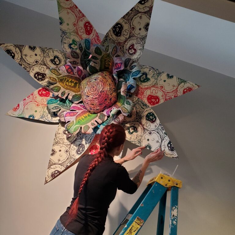 Artist Stephanie Berrie installs an element of her hand-printed fiber installation, “A Monstrous Garden” in January 2025. Courtesy of Fitton Center for Creative Arts