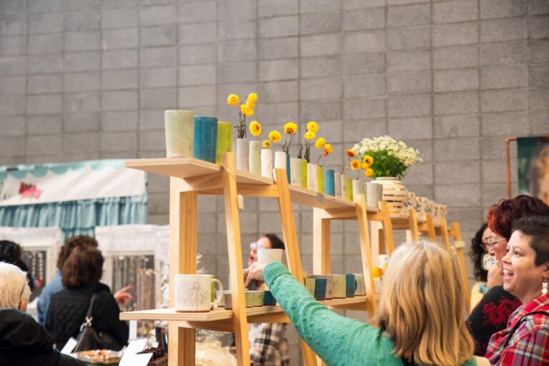 Shoppers at Handmade Arcade's 2023 Holiday Market admire products from Jenna Vanden Brink Ceramics. Maker Products Pictured: Jenna Vanden Brink Ceramics (Photo Credit: Kitoko Chargois, courtesy of Handmade Arcade)