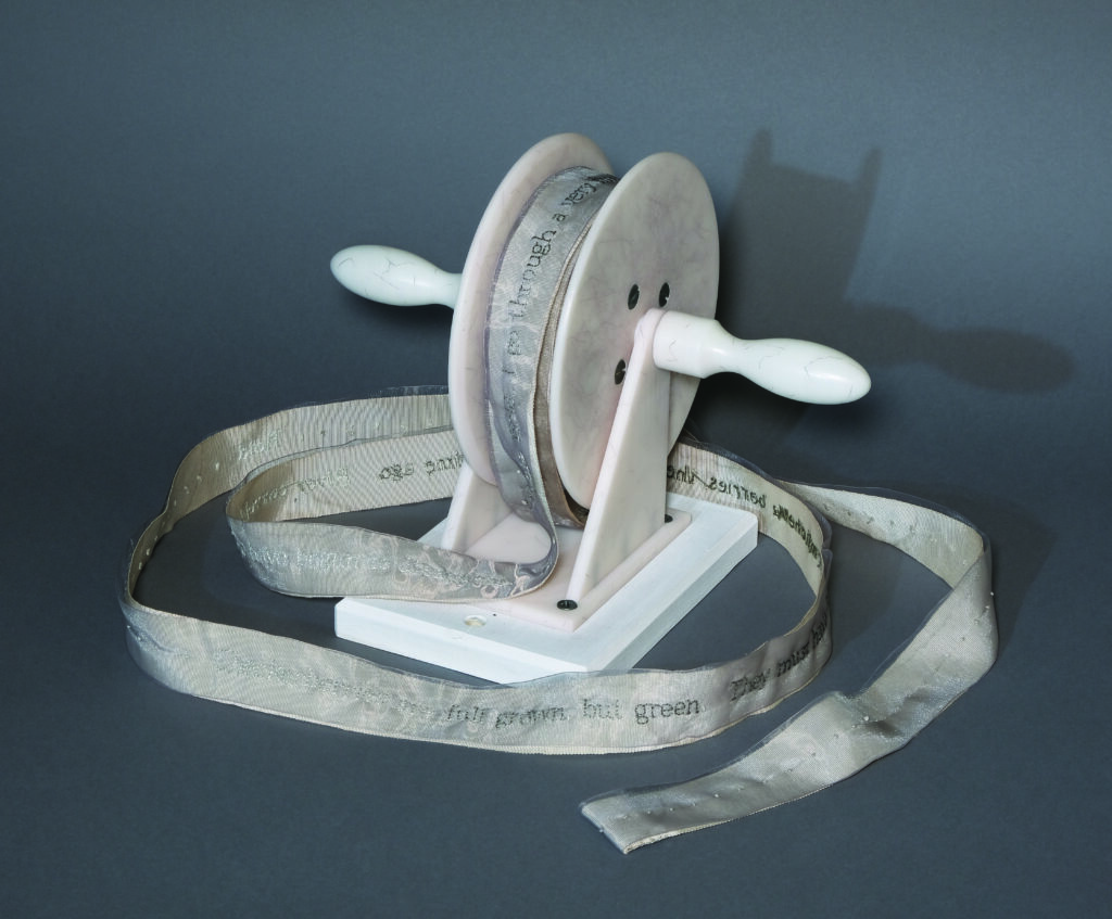 Kathy Kuehn (Portland, OR), Field, 2003, Tuille, grosgrain ribbon on composite spindle by Tim Moore, with 2823 French knots; text by Henry David Thoreau, September 11, 1853, journal entry, ribbon: 1.5”w x 50’l; spindle: 8”h x 7”w x 12”d, unique, photo by Hunter Stroud