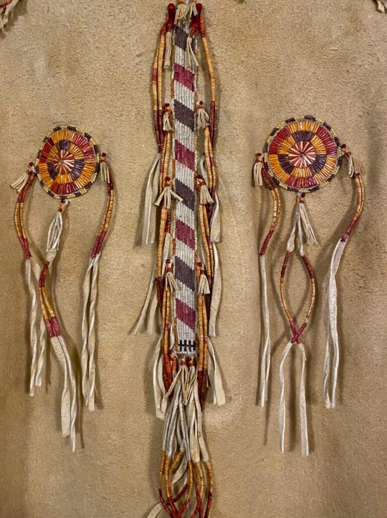 Detail of "Quilled Jacket with Shirt and Trousers" by Joe Savage, Porcupine quills, trade beads, buckskin, sinew, basswood bark fibers, natural dyes, brass button bases, woven, stitched, edged, sewn, ric rac quillwork. Joe Savage