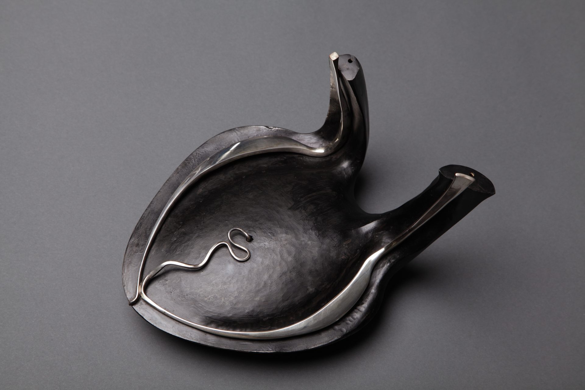 Wearable art in silver and iron holder by master metalsmith, Heikki Seppä. Heikki Seppä (1927-2010, Finland/Bainbridge Island, WA), Iron Heart, 1973, blackened iron, sterling silver, BIMA Permanent Art Collection, Gift of Laurie A. Lyall, Photo by CB Bell