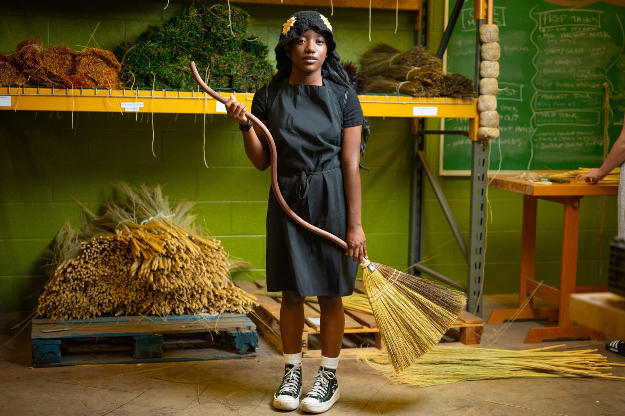 Student Bre '28 with the handmade Squiggle Broom. Bre, like so many students was randomly assigned a Labor Position within the Broom shop as a first year student. Now a sophomore Bre has become an integral part of the studio. Sean Hall '25 and Evy Medley '25