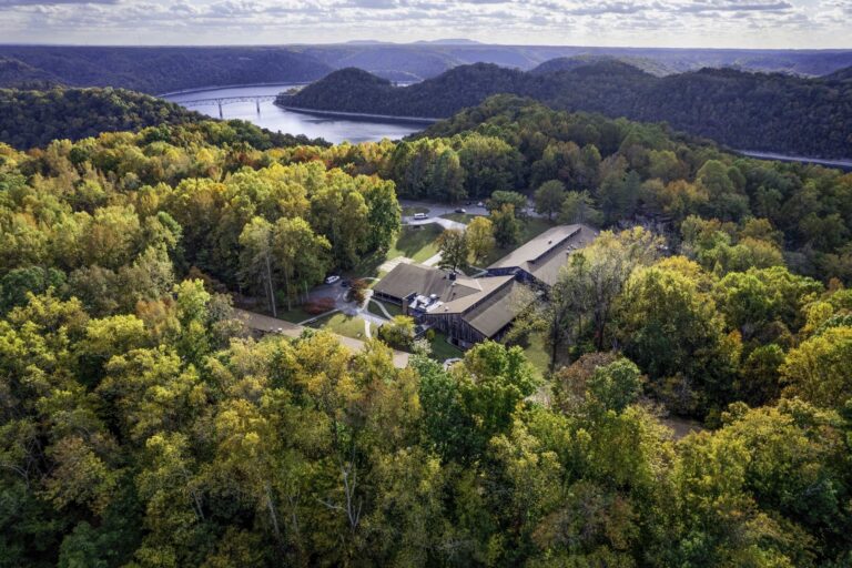 Aerial image of the Appalachian Center for Craft featuring its beautiful location surround by pristine hills covered in autumn colored trees and the surrounding Center Hill Lake. TN Tech University Photographic Services