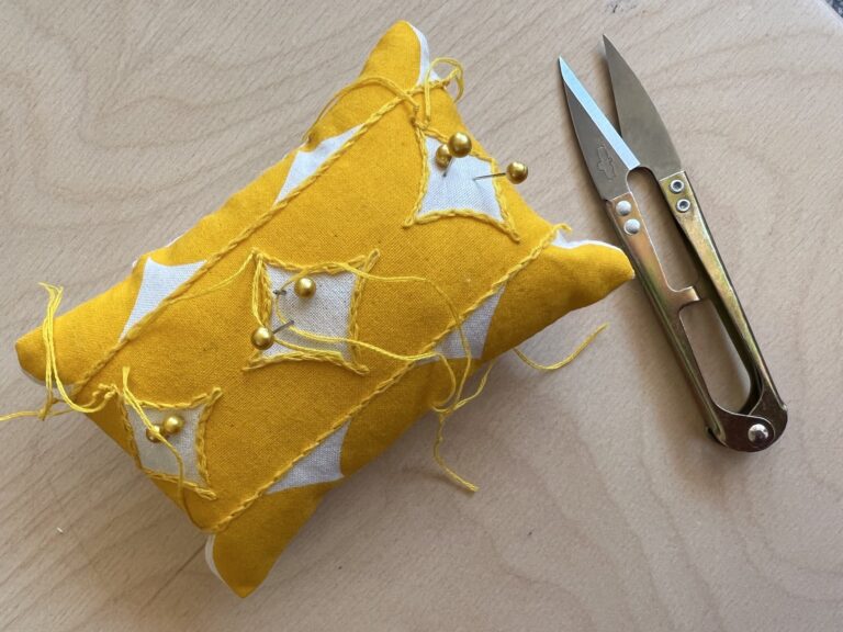 Yellow Pincushion with pins and thread. American Swedish Institute Yellow Pincushion with pins and thread. American Swedish Institute