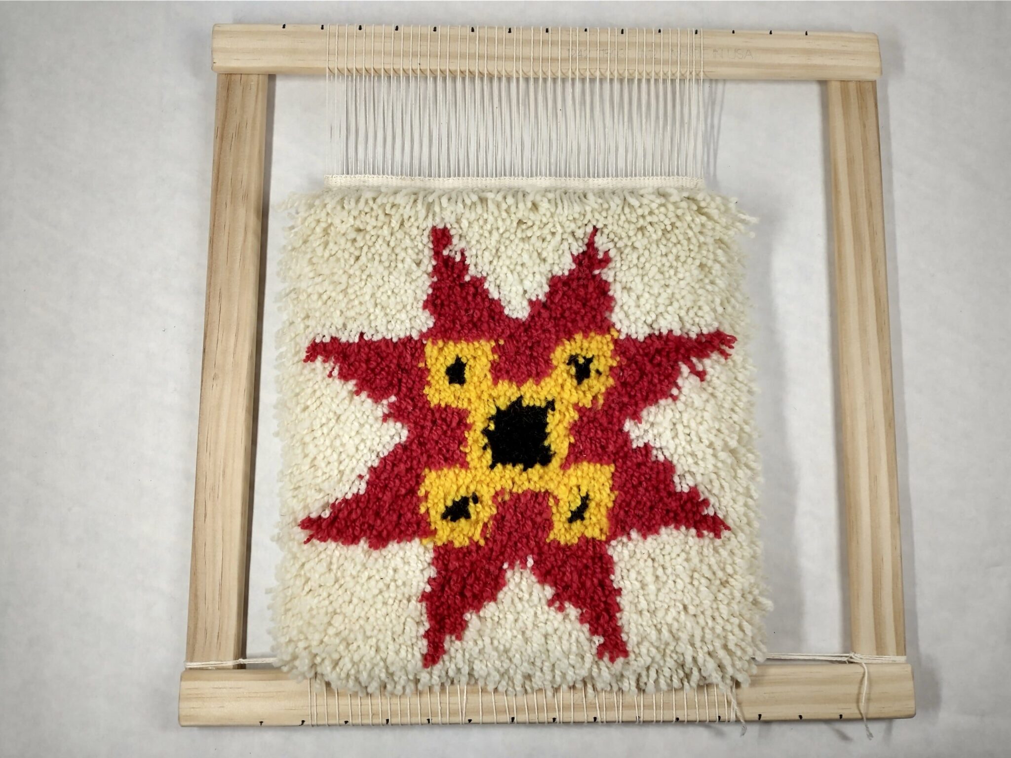 Rya tapestry of a star on a loom. American Swedish Institute