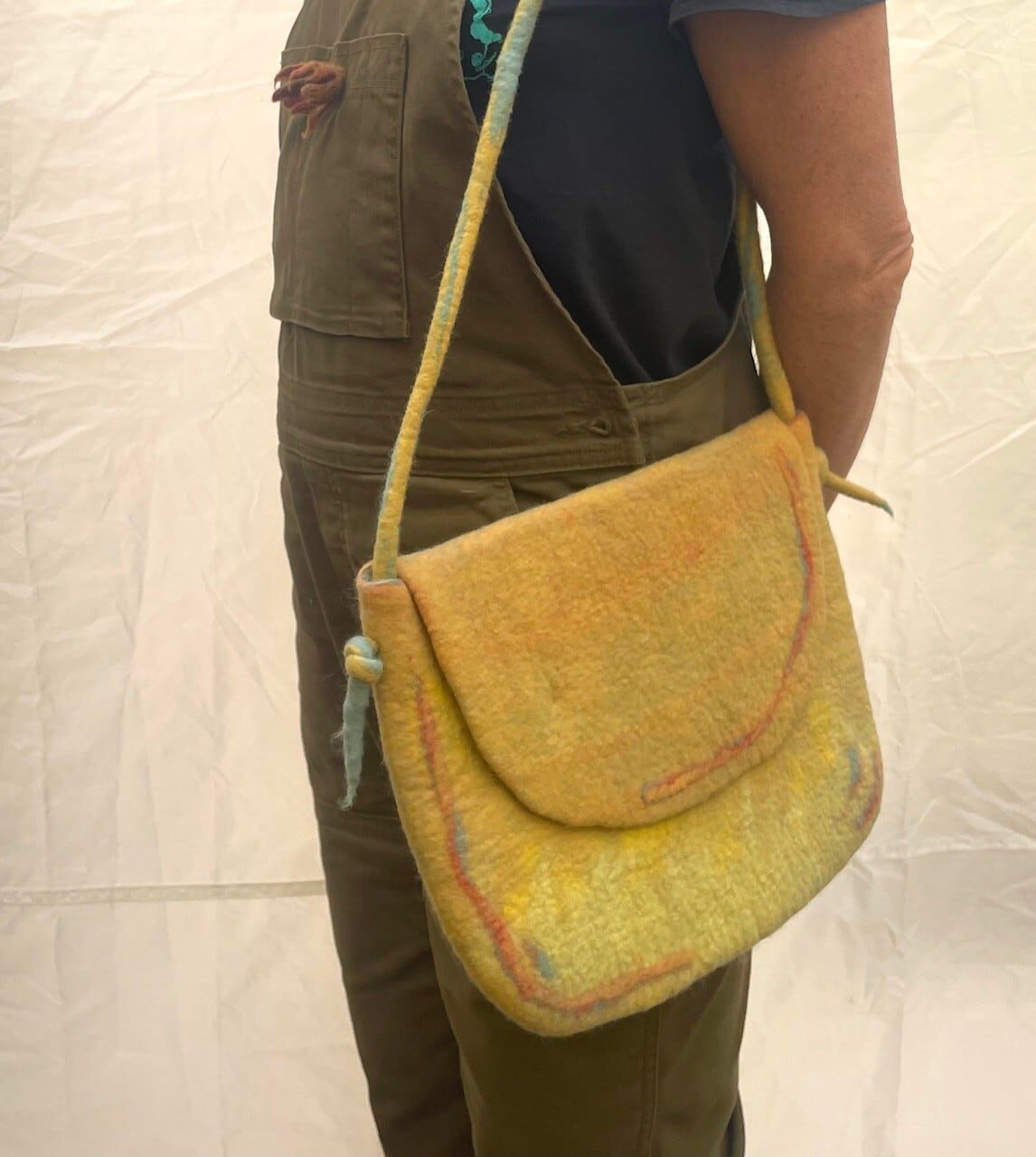 Wet felted shoulder bag worn around the sholder. American Swedish Institute