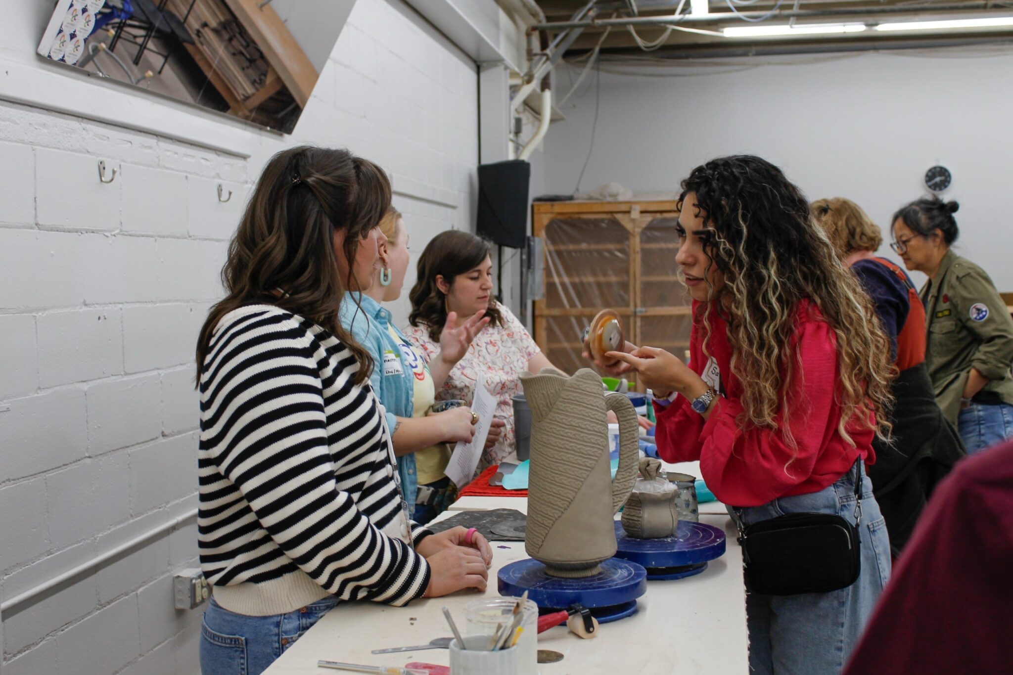 Artist talking to student in the Northern Clay Center studios. Northern Clay Center
