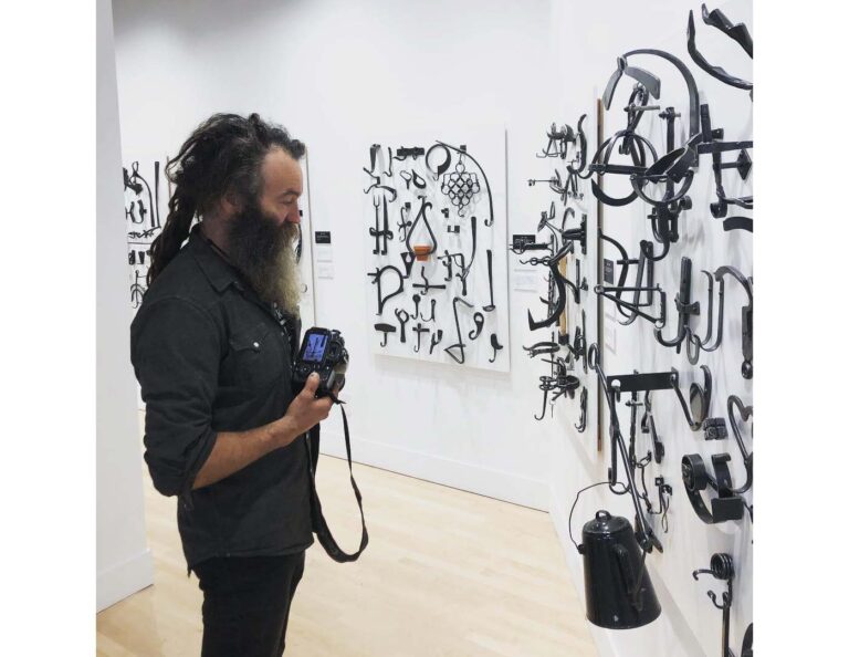 A gallery patron views the #366Hooks exhibition featuring work by Matt Jenkins. This exhibition toured the US with support from ABANA. Photo by the Manitoba Craft Council. A gallery patron views the #366Hooks exhibition featuring work by Matt Jenkins. This exhibition toured the US with support from ABANA. Photo by the Manitoba Craft Council.