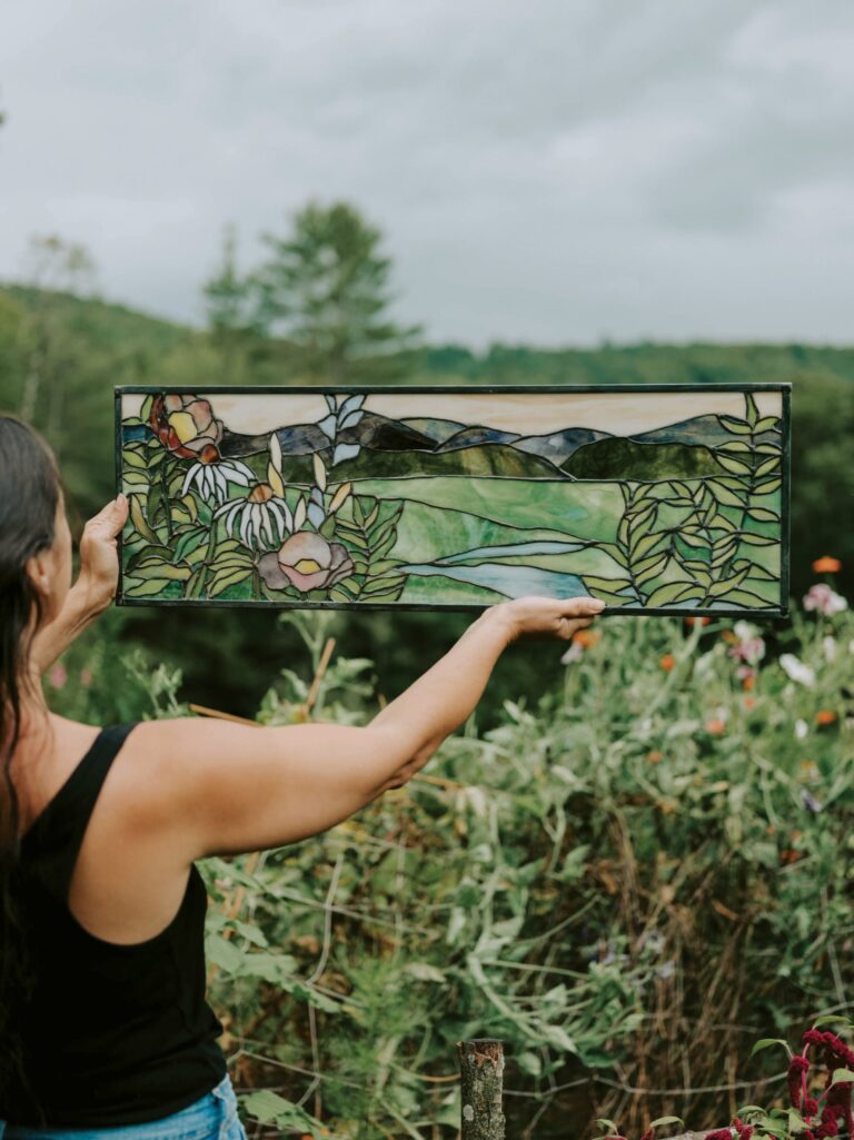 Dayna Sabatino of Day Breaks Glass Studio, holds up a panel that she made. Dayna Sabatino