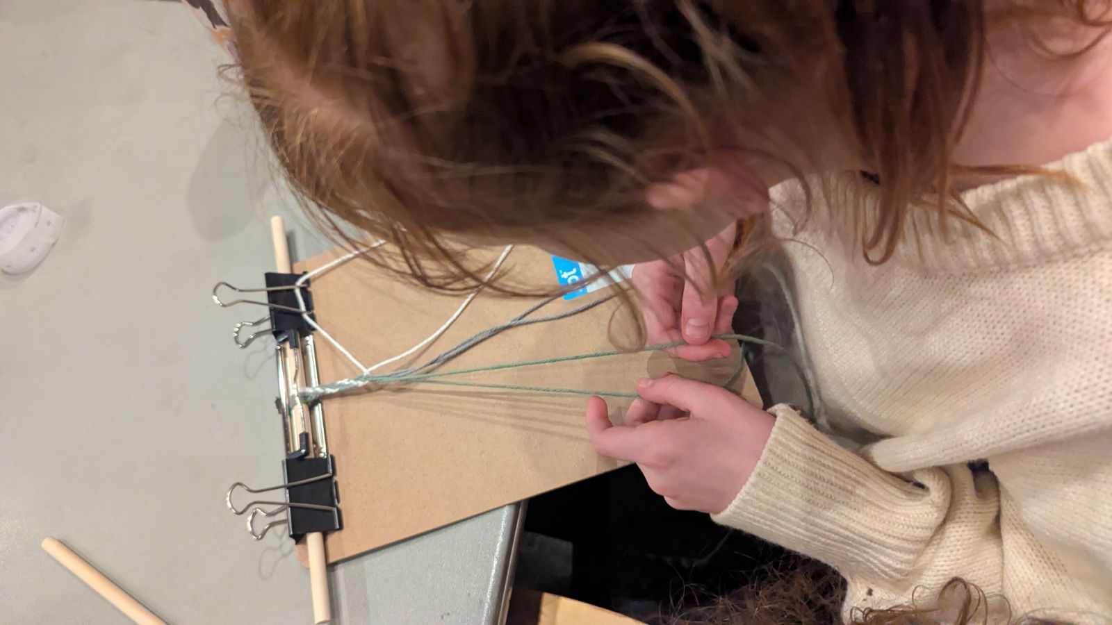 A student working on finger weaving. Annalise Christensen