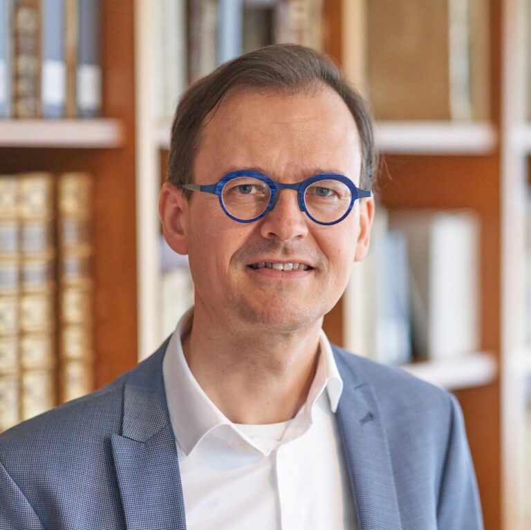 Headshot photo of Dr. Joran Proot, a man with short brown hair and circular blue glasses. Image courtesy of Dr. Proot