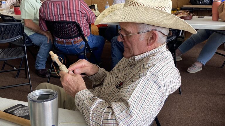 Rawhide braider working at the gathering. Emma George