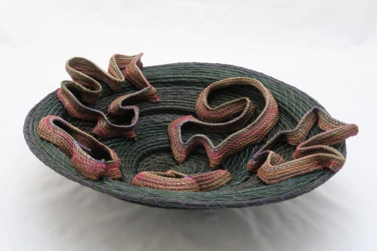 Counterpoint, by Nolan Wright - 2019 - 4.5" (t) x 16" (w) x 16" (d) - Dyed pine needles, coiled with waxed linen. Additional biomorphic shapes "sketched" on and coiled in place using waxed linen. Nolan Wright