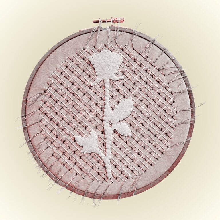An embroidery hoop with an appliqued rose and stitched background. Credit: Carolyn Drake
