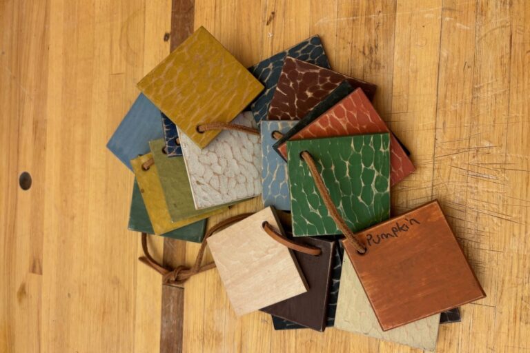 A pile of colorful wood sample swatches on a wooden surface. American Swedish Institute