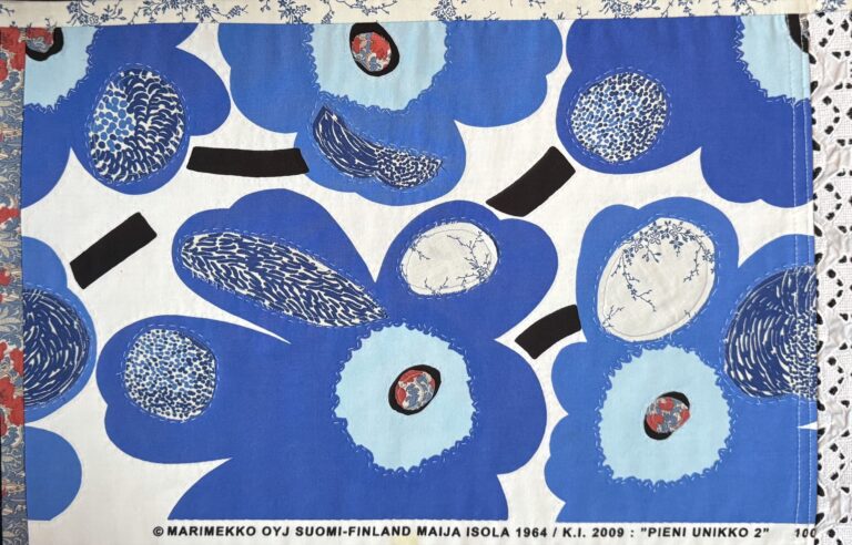 A Marimekko pattern is overlayed with fabric pieces and embroidery and then framed in complementary fabric and lace to create a unique art piece that also happens to be a placemat. A Marimekko pattern is overlayed with fabric pieces and embroidery and then framed in complementary fabric and lace to create a unique art piece that also happens to be a placemat. Photo by V. Reinke