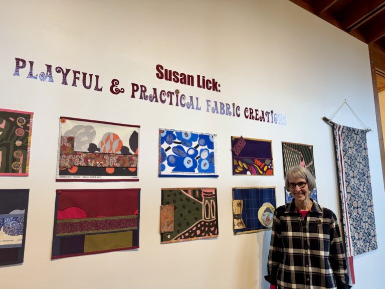 “Sewist” Susan Lick poses in front of her work. Her unique creations are beautifully hand-crafted and often practical in nature like placemats and tote bags. The exhibit also includes banners she’s designed, colorful fabrics collaged and embellished with embroidery, buttons, beading, and piping "Sewist" Susan Lick poses in front of her work. Her unique creations are beautifully hand-crafted and often practical in nature like placemats and tote bags. The exhibit also includes banners she's designed, colorful fabrics collaged and embellished with embroidery, buttons, beading, and piping. Valerie Reinke, Bainbridge Island