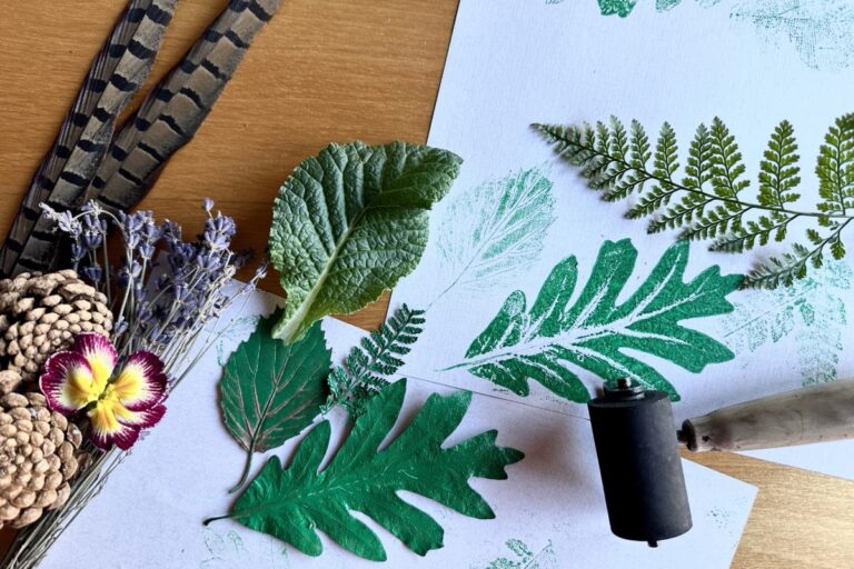 Leaves, feathers, and flowers being used to make prints on paper. American Swedish Institute