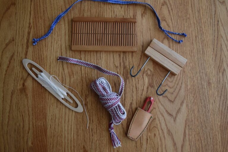 Weaving tools and materials arranged on a wooden surface. American Swedish Institute