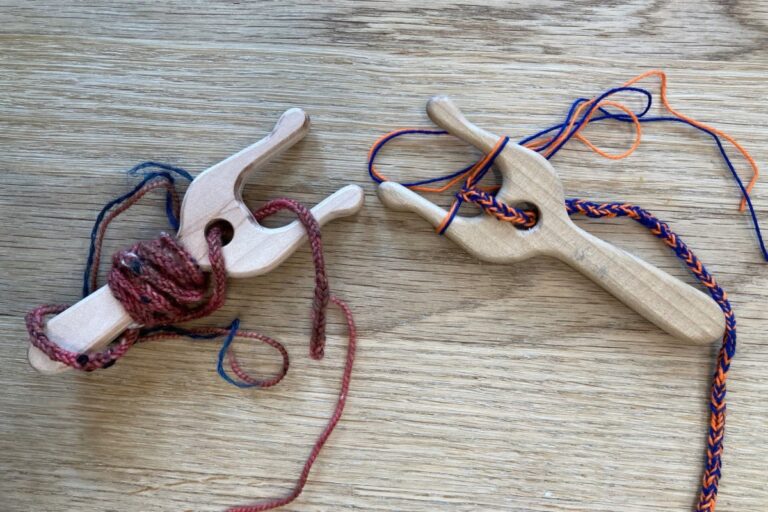 Wooden looms braiding colorful yarn on a wooden surface. American Swedish Institute