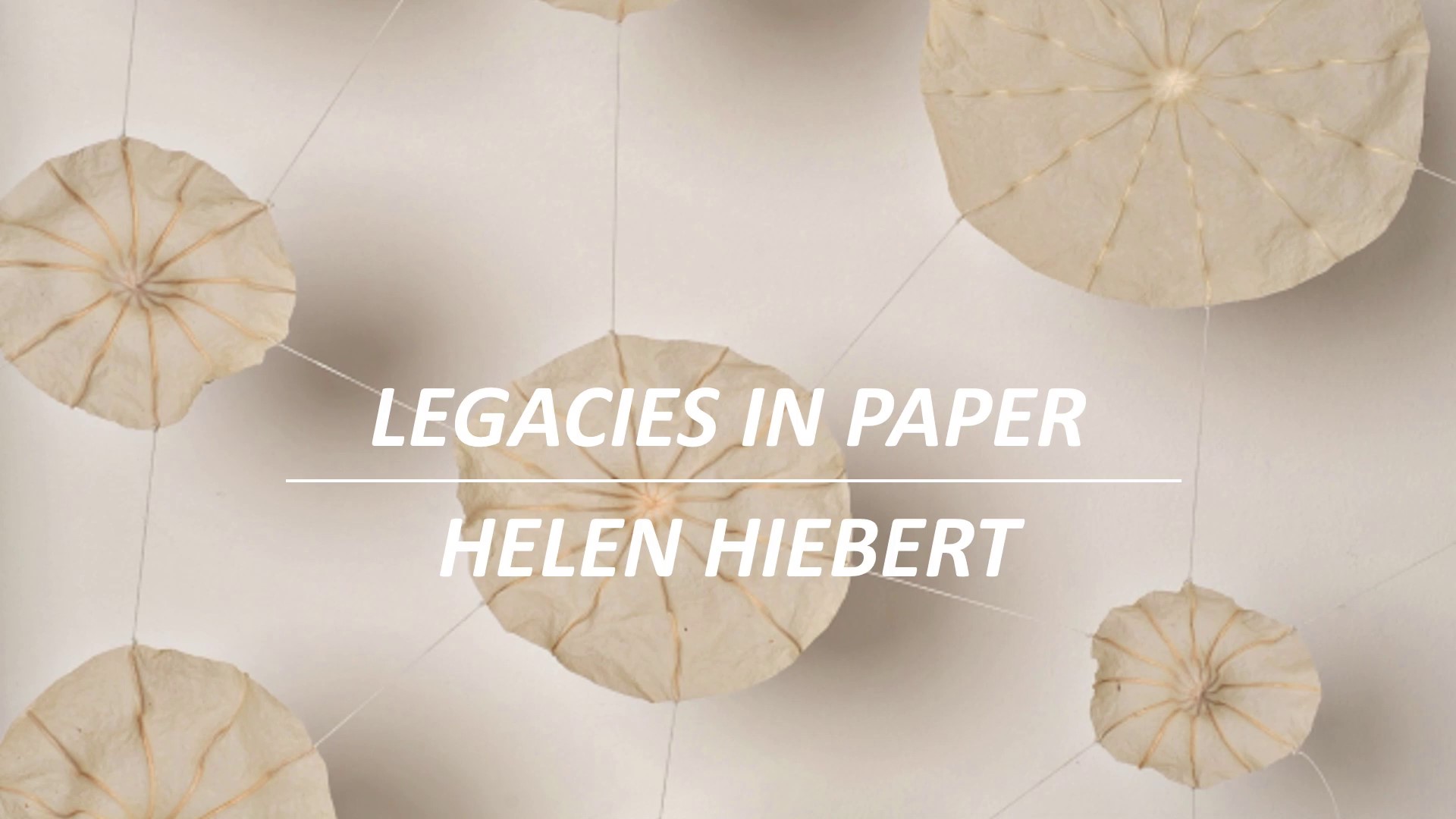 Legacies in Paper: Helen Hiebert in white text, over several abaca paper disks connected by threads. Image courtesy of Helen Hiebert.