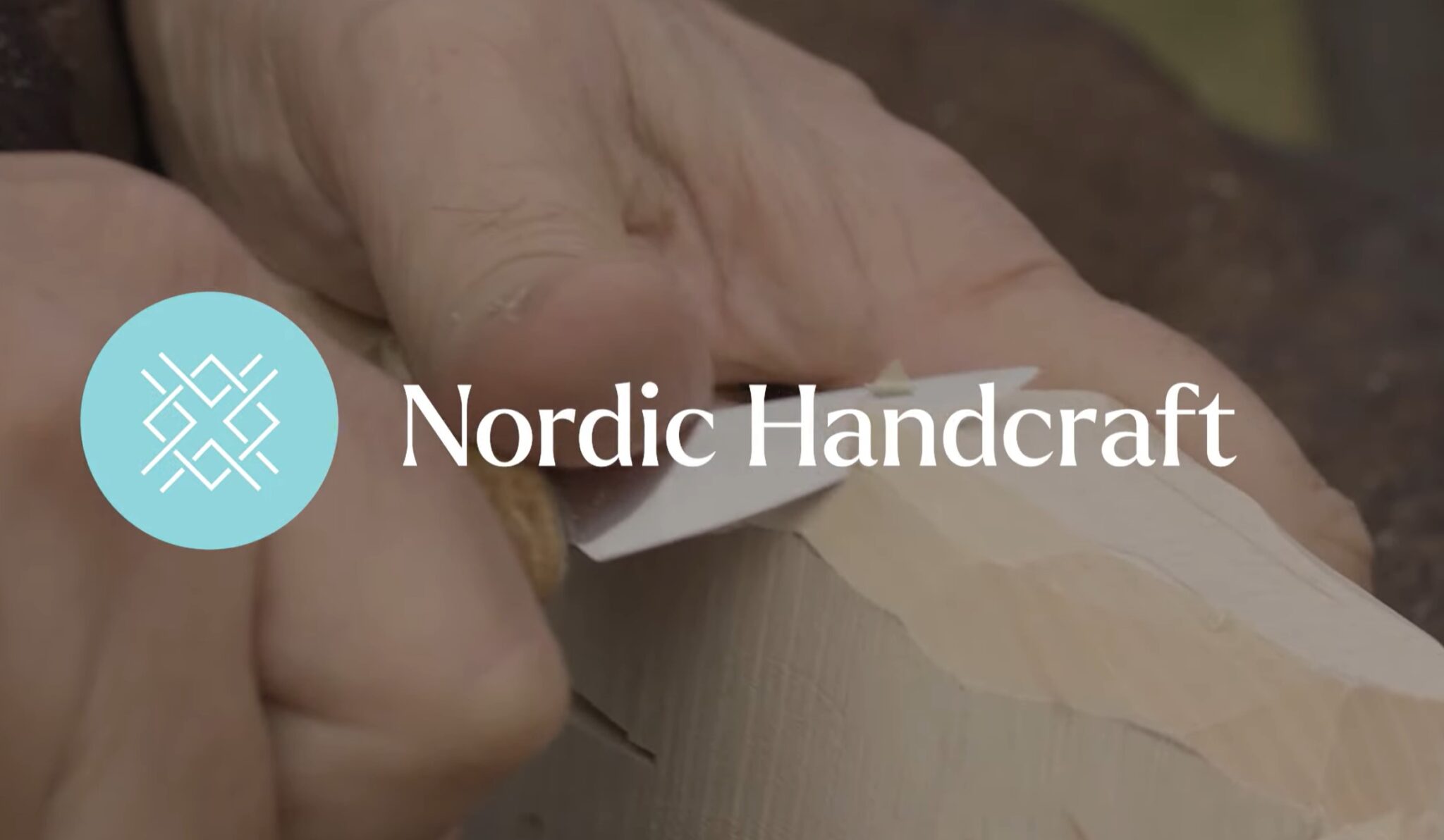 A close up of a hand carving wood with a knife. American Swedish Institute