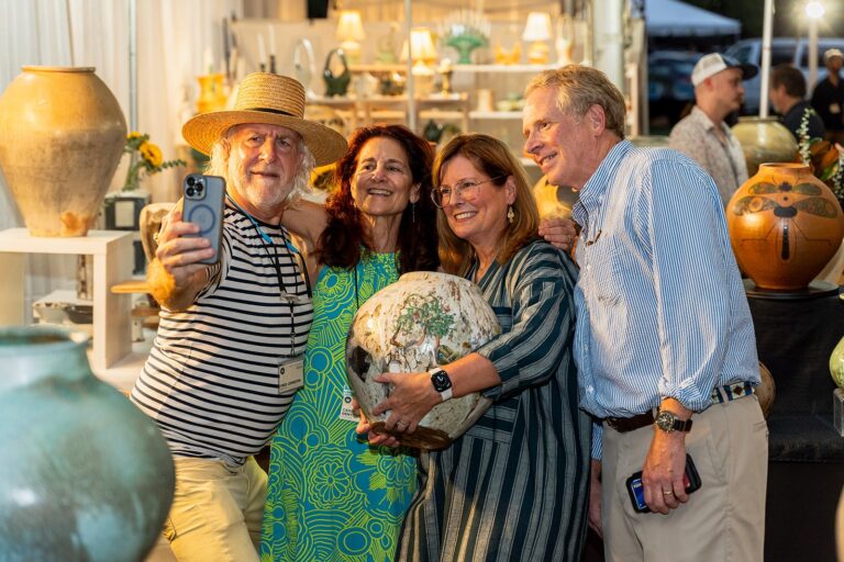 A participating potter poses for a photo with guests during Potters Market at the Mint at Mint Museum Randolph A participating potter poses for a photo with guests during Potters Market at the Mint at Mint Museum Randolph. Photo by Adam Eugene Photo