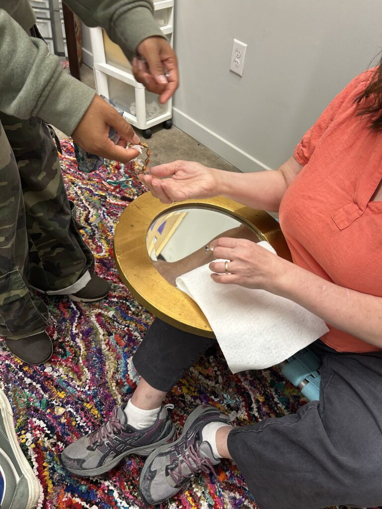 Hand of Cheryl and Amaka exchanging and discussing materials Hand of Cheryl and Amaka exchanging and discussing materials. Kade Sawyer