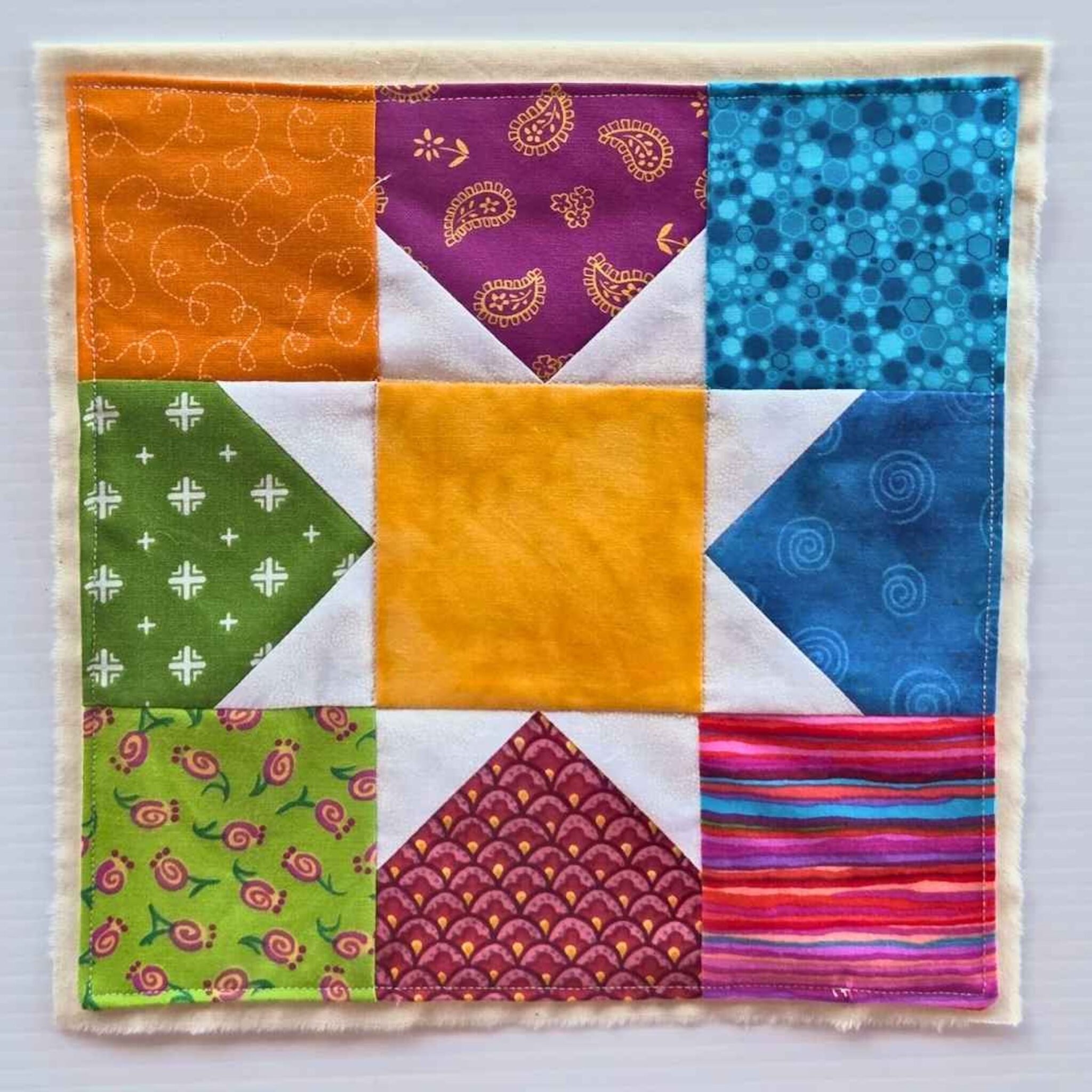 Flag made by the Mill to Mill Textile Fellowship. Pieced patchwork square in quilting cotton on muslin. image courtesy of the Red Mill Museum Village