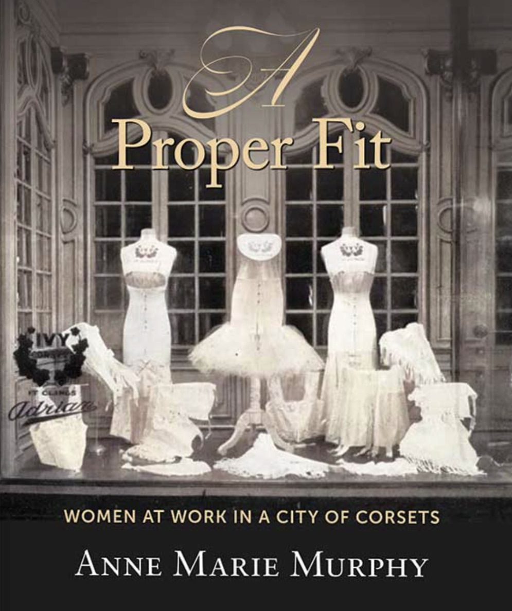 Dress forms with corsets on them sitting on a table in a large elegant room