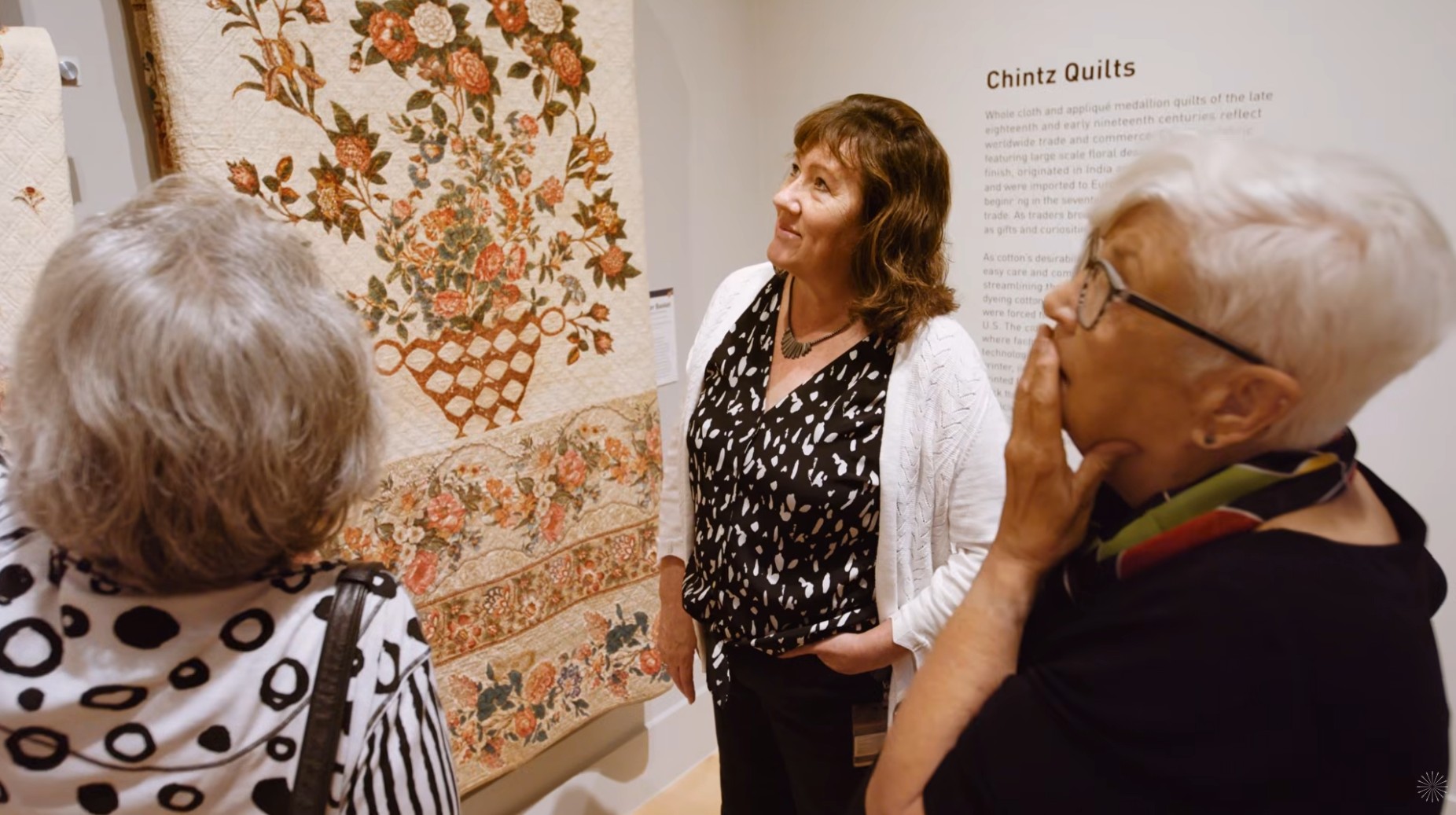Carolyn Ducey (center) looks at quilts with guests at the IQM. International Quilt Museum, University of Nebraska–Lincoln