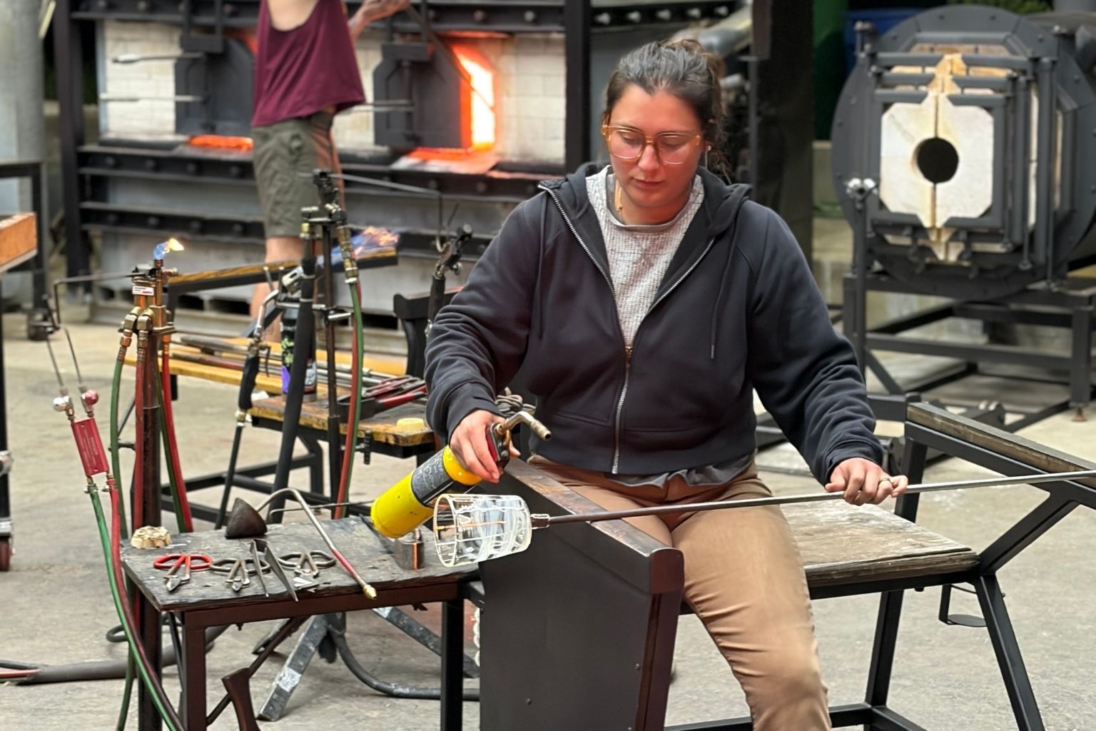 Artist Emily Potter blowing glass. Image provided by artist