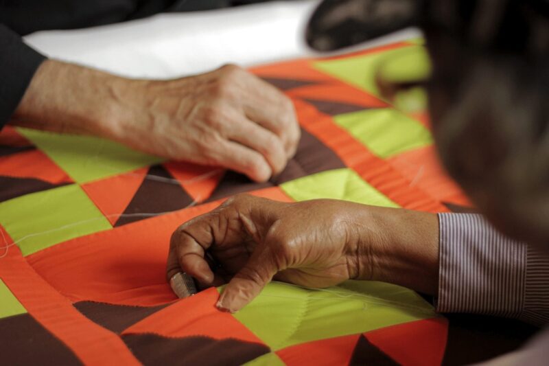 Gee's Bend group stitching a quilt