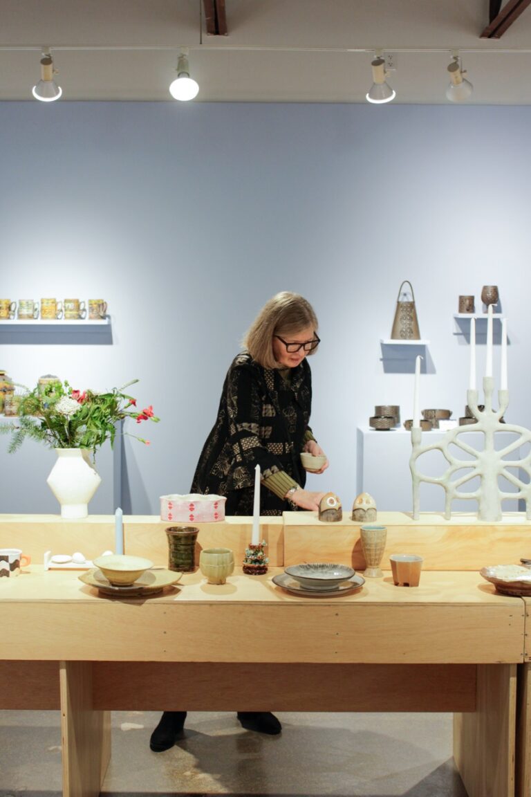 Visitor shopping the Winter Exhibition. Northern Clay Center